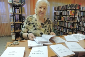 Член ВОИ Алина Антоновна Черноус выбирает книгу для слабовидящих людей