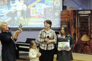 Директор библиотечной системы Ефименко О.А. вручает подарок семье Крыжановских, победителю в номинации «Самая читающая семья»