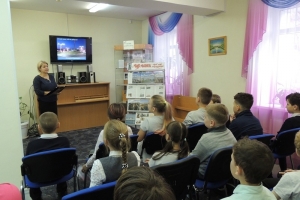 Библиотекарь Евгения Валерьевна читает ребятам стихотворение Александра Подстаницкого «Мурманск вечером»